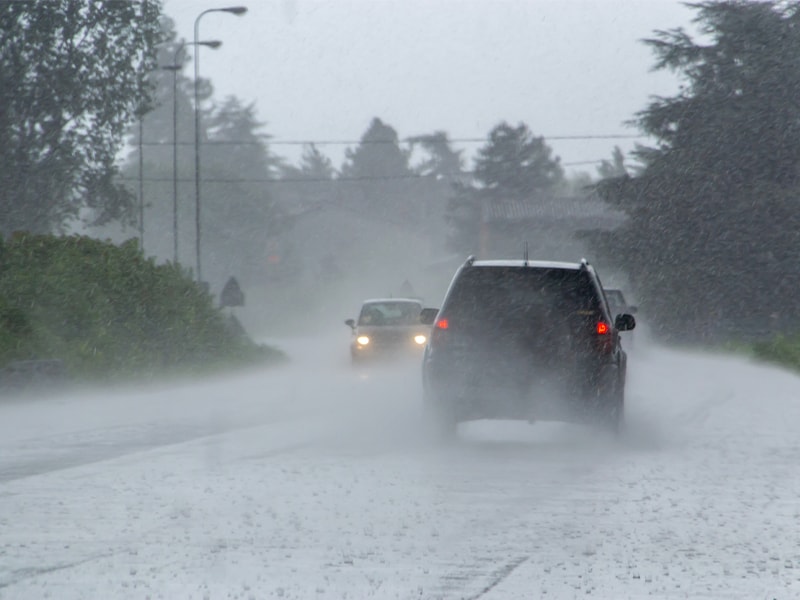 Cars on a wet street under heavy rainfall and showcasing need for weather monitoring